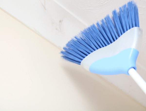 Removing cobwebs from ceiling — technique matters.
